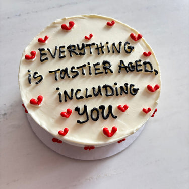 Кръгла кремава торта с рисунка и надпис 'EVERYTHING is TASTIER AGED, INCLUDING you'.