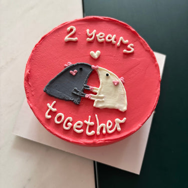 Кръгла червена торта с рисунка и надпис 2 years together.