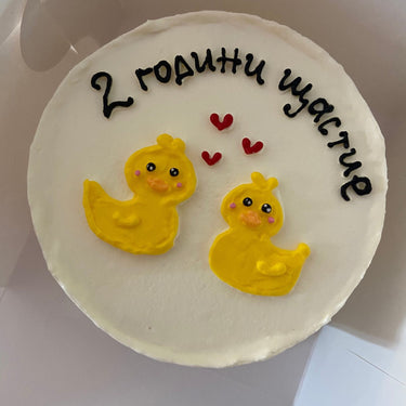 Кръгла бяла торта с рисунка и надпис '2 години щастие' за годишнина