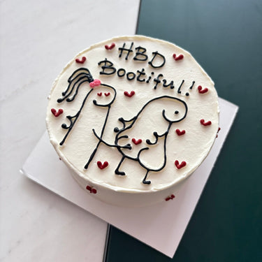 Кръгла бяла торта с рисунка на човечета и надпис 'HBD Bootiful!!'
