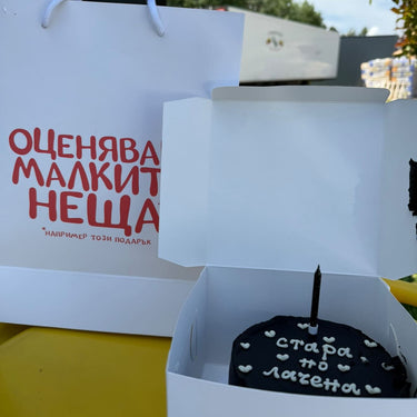 Кръгла черна торта с надпис 'стара по лачена', без допълнителна украса.